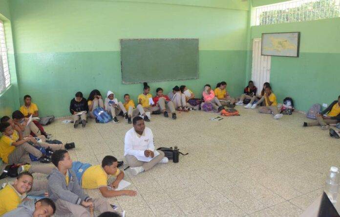 Estudiantes reciben clases en el piso por falta de butacas en escuela de Santiago