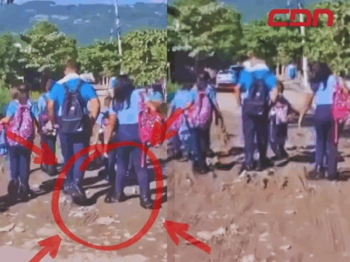 Denuncian mal estado de vía en Jacagua obliga a niños a usar fundas plásticas en zapatos para asistir a clases